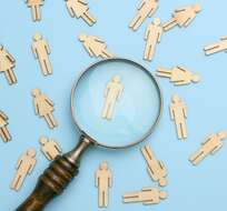 wooden-men-and-a-magnifying-glass-on-a-blue-backgr-2025-03-24-07-48-30-utc-min